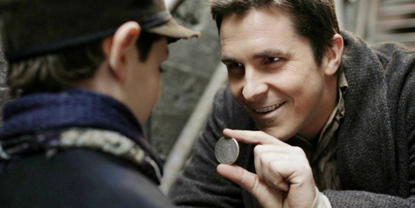 Christian Bale showing a coin to a child in The Prestige