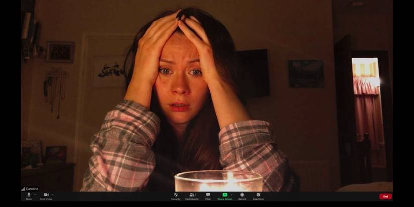 A woman looking worried with her hands on her face in Host on Shudder