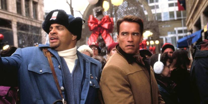 Arnold Schwarzenegger as Howard and Sinbad as Myron in a crowd looking annoyed in Jingle All the Way.