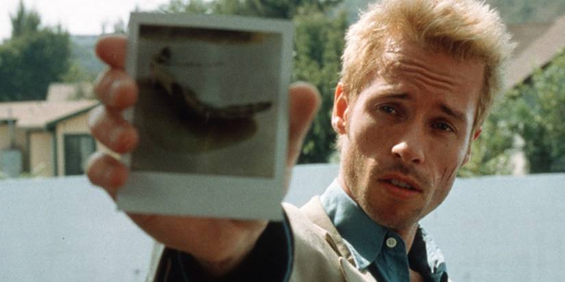 Guy Pearce as Leonard holding up an instant photo in Memento.