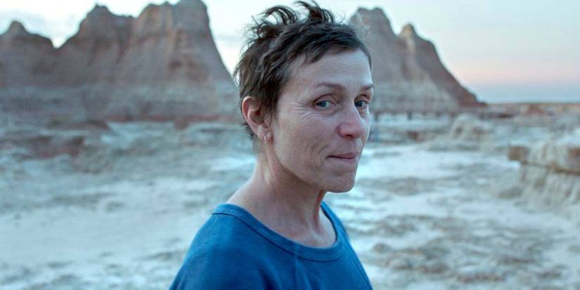 Frances McDormand smiling softly while looking at the camera in Nomadland