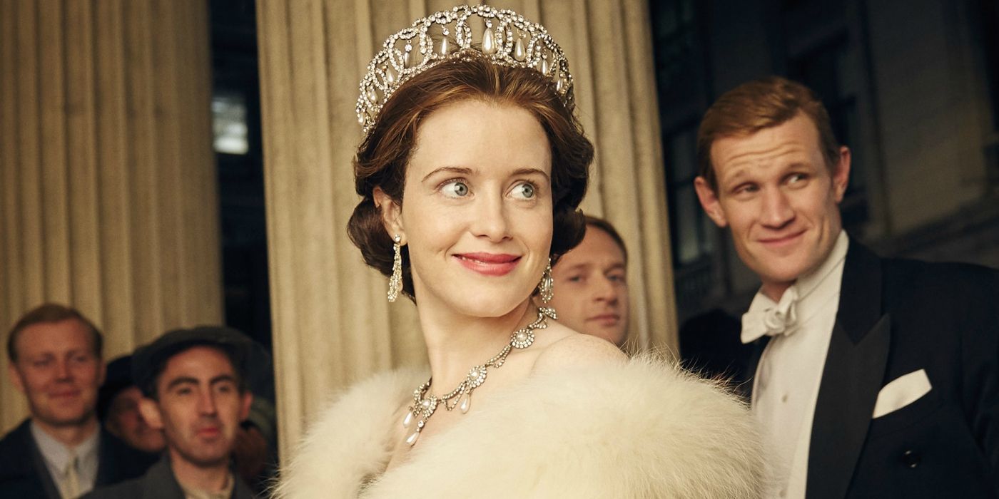Claire Foy and Matt Smith dressed as their characters and smiling at a fancy party in The Crown.