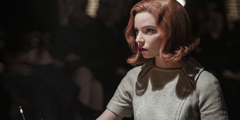 Anya Taylor-Joy lit by a spotlight, looking ahead in Netflix's The Queen's Gambit.