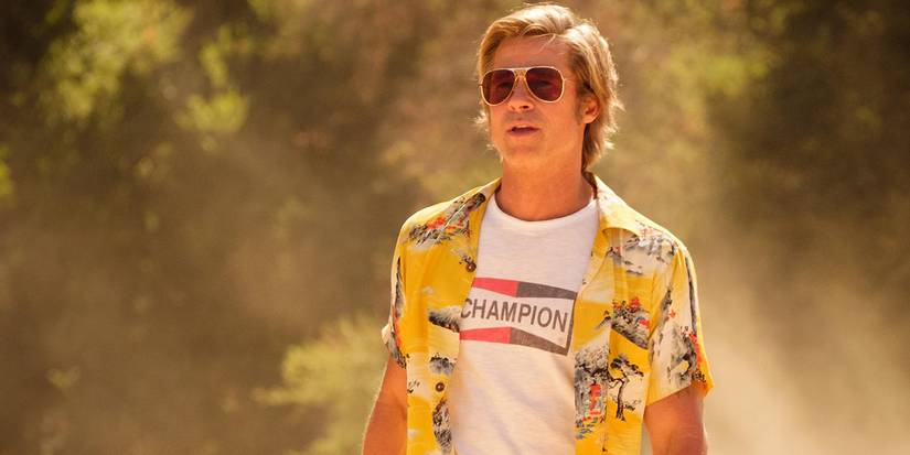 Brad Pitt as Cliff Booth walking in a desert area surrounded by dust in Once Upon a Time... in Hollywood.