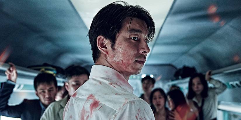 A man covered in blood turns around while train passengers stand in front of him in Train to Busan