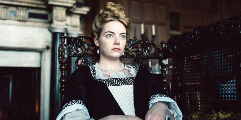 Emma Stone as Abigail Masham, sitting in a chair and looking bored in The Favourite