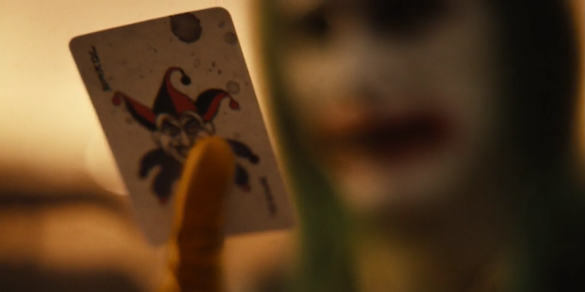 Jared Leto's Joker holding out a Joker card in Zack Snyder's Justice League