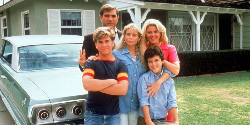 The cast of The Wonder Years posing by their car.