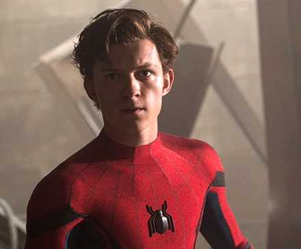 Tom Holland as Spider-Man with his mask off frowning and looking ahead into the camera in Spider-Man: Homecoming