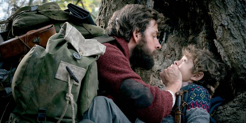 Lee Abbott (John Krasinski) yang meliputi mulut Marcus (Noah Jupe) saat mereka bersembunyi di luar di tempat yang tenang
