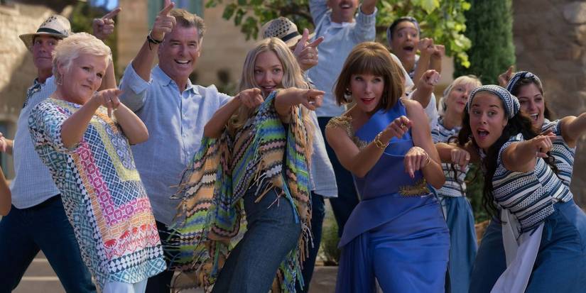 The cast of Mamma Mia! Here We Go Again sining and pointing in the same direction