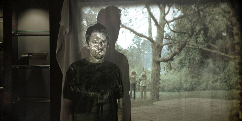 Ethan Hawke stands in front of a projector screen as the footage plays over him