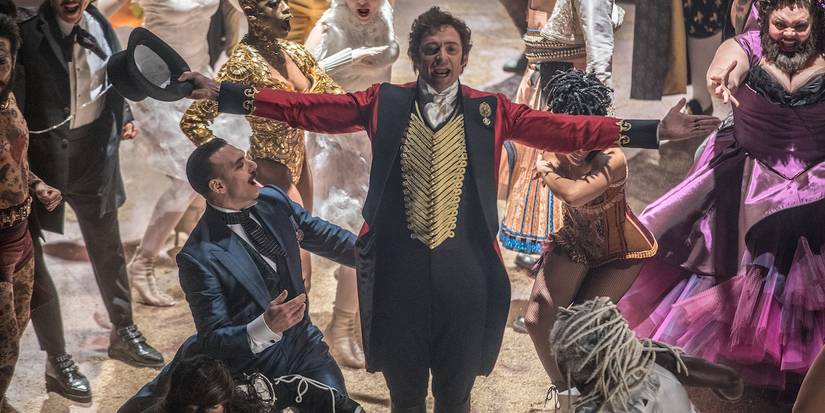 Hugh Jackman as P.T. Barnum singing, surrounded by his performers in The Greatest Showman.