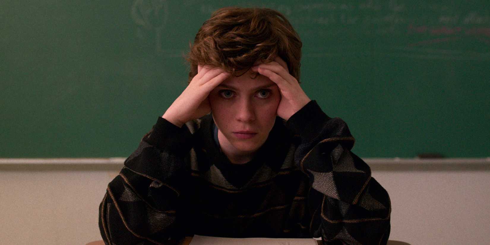 Sophia Lillis sits with head resting in hands and staring ahead with angst in I Am Not Okay with This.