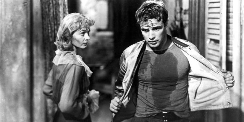 Blanche DuBois and Stanley Kowalski covered in grease and removing his overshirt in A Streetcar Named Desire.