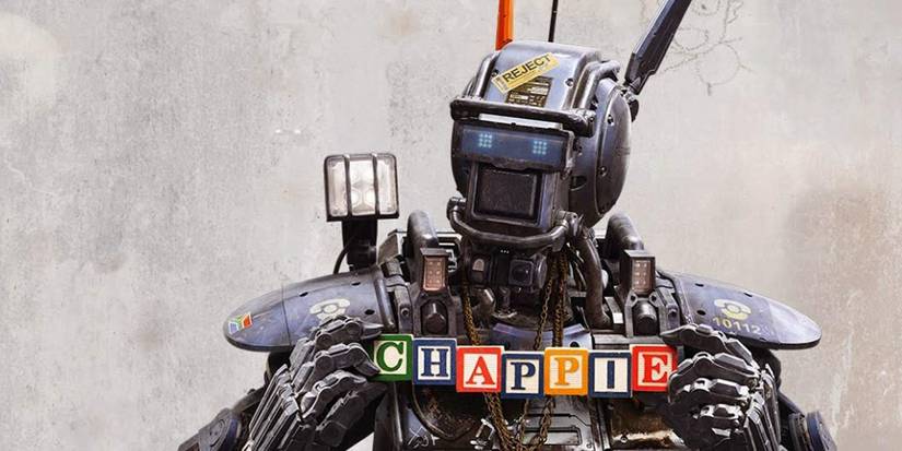 A robot holding up toy letter blocks that spell his name in the film Chappie
