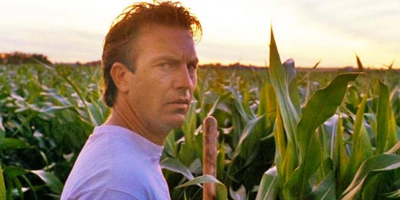 Kevin Costner as Ray Kinsella standing in his cornfield looking confused in Field of Dreams.