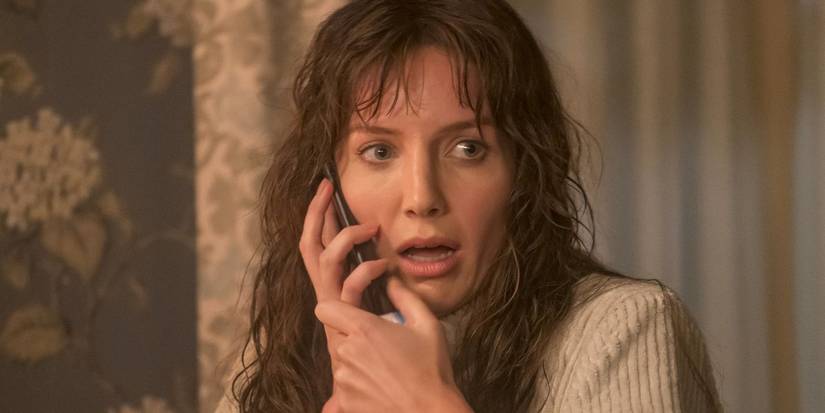 Annabelle Wallis talks on a phone and looks alarmed in Malignant.