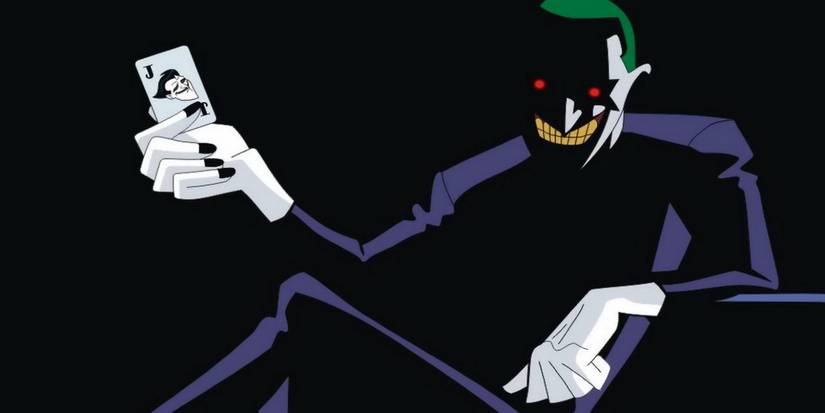 Joker holding up a joker playing card in a dark room in Batman Beyond Return of the Joker.