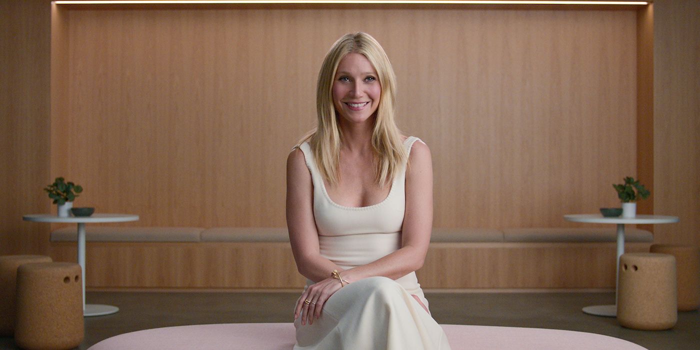 Gwyneth Paltrow sitting down and smiling while looking at the camera in Sex, Love, &amp; Goop