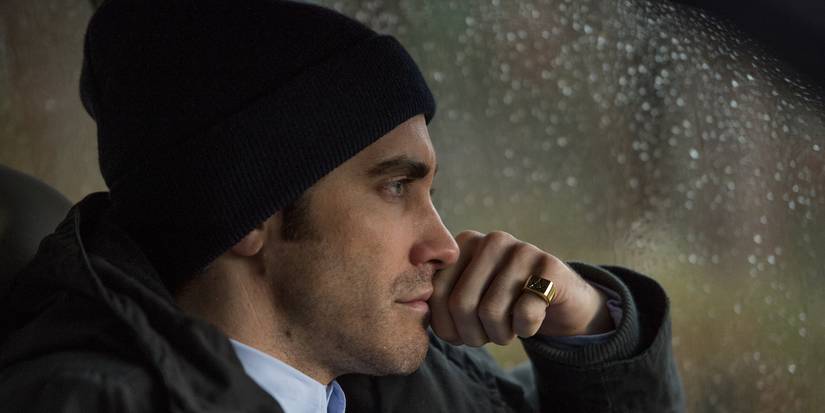 Jake Gyllenhaal as Loki sitting inside a car, lost in thought in Prisoners