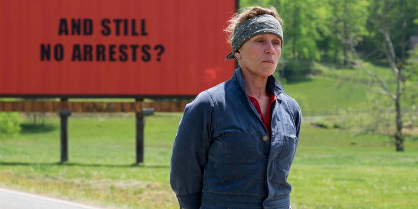 Frances McDormand as Mildred Hayes, standing by a billboard and looking sad in Three Billboards Outside Ebbing, Missouri