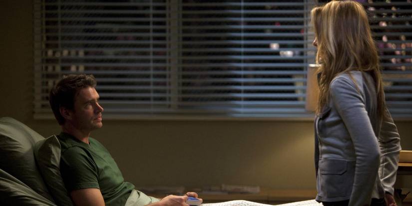 Scott Foley as Henry in a hospital bed looking sadly at Kim Raver as Teddy on Grey's Anatomy.