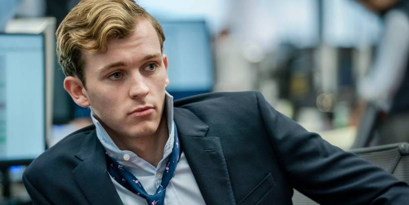 Harry Lawtey wearing a suit in a newsroom in Industry