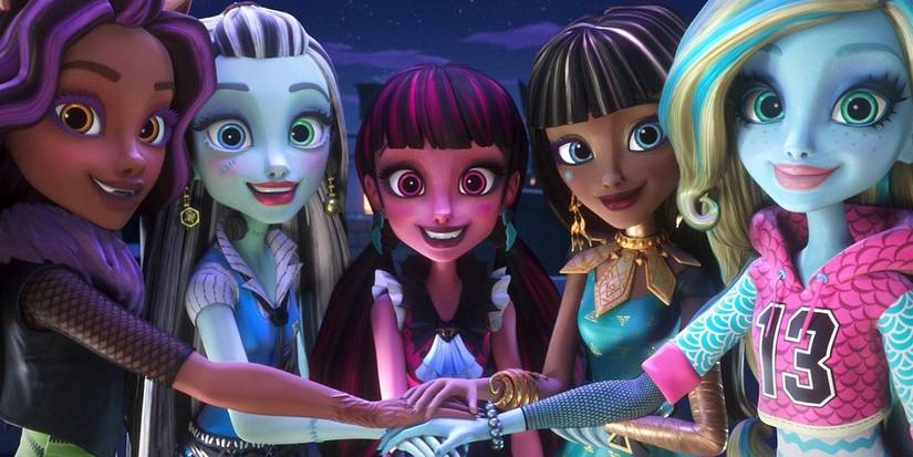 The characters in Monster High put their hands in together and smile at the camera.