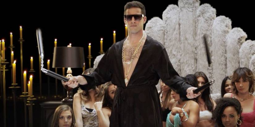And Samberg as Rap pop star Connor Friel wielding nunchucks in front of a group of women. 