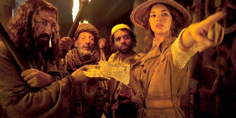 Adèle holds a parchment and points ahead as a group of others gathers around in The Extraordinary Adventures of Adèle Blanc-Sec.