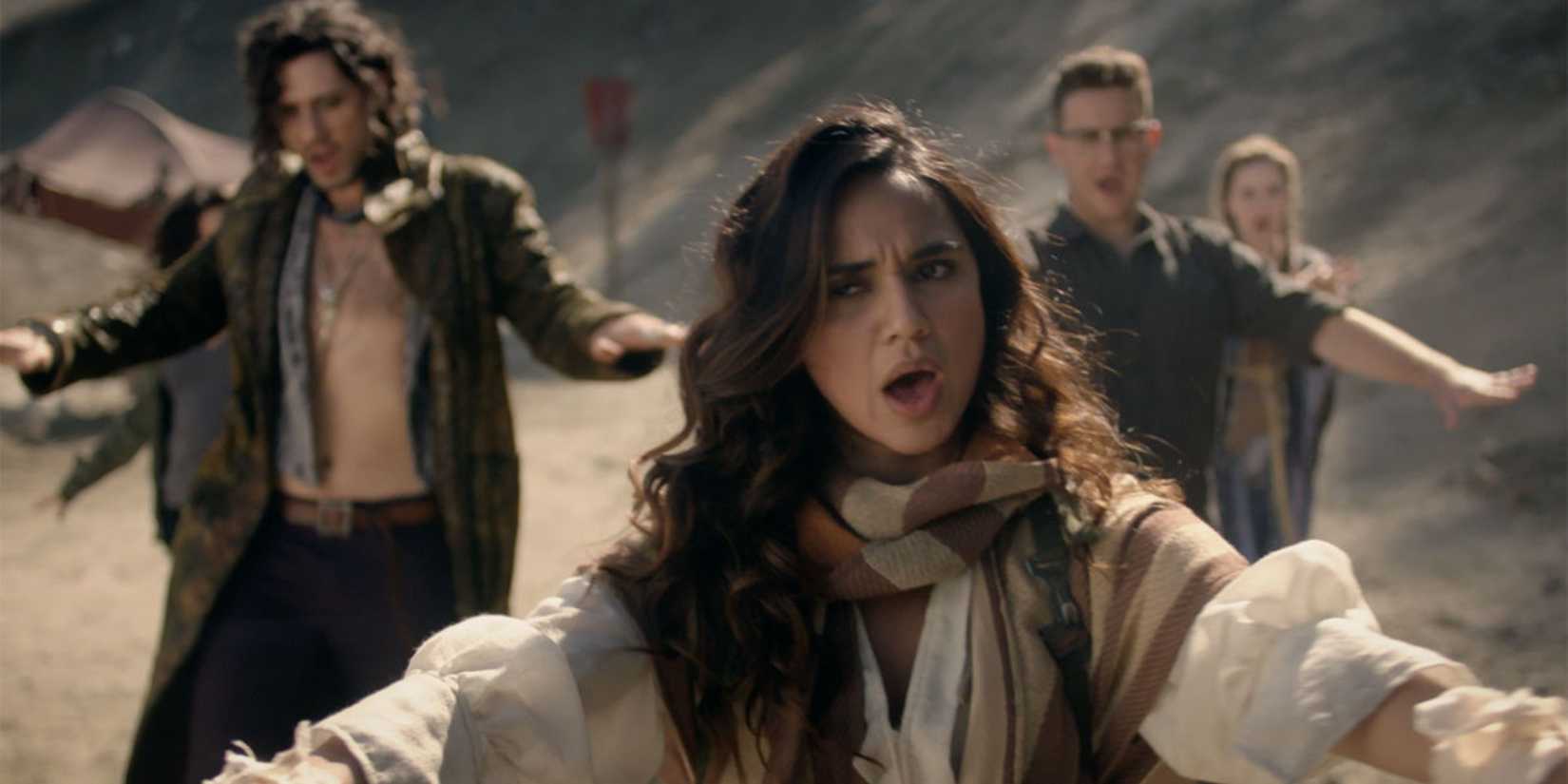 A group of people outdoors hold their arms up and mouths open in The Magicians.