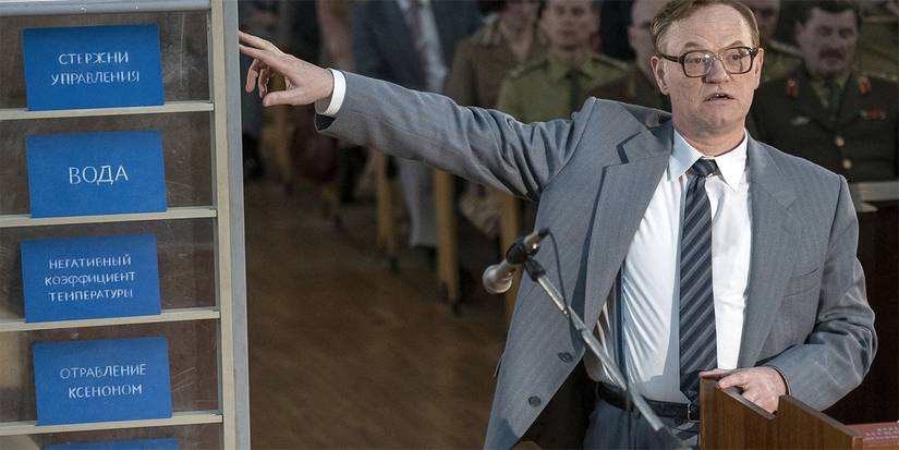 Jared Harris as Valery Legosov speaks at a symposium with an audience behind in Chernobyl.