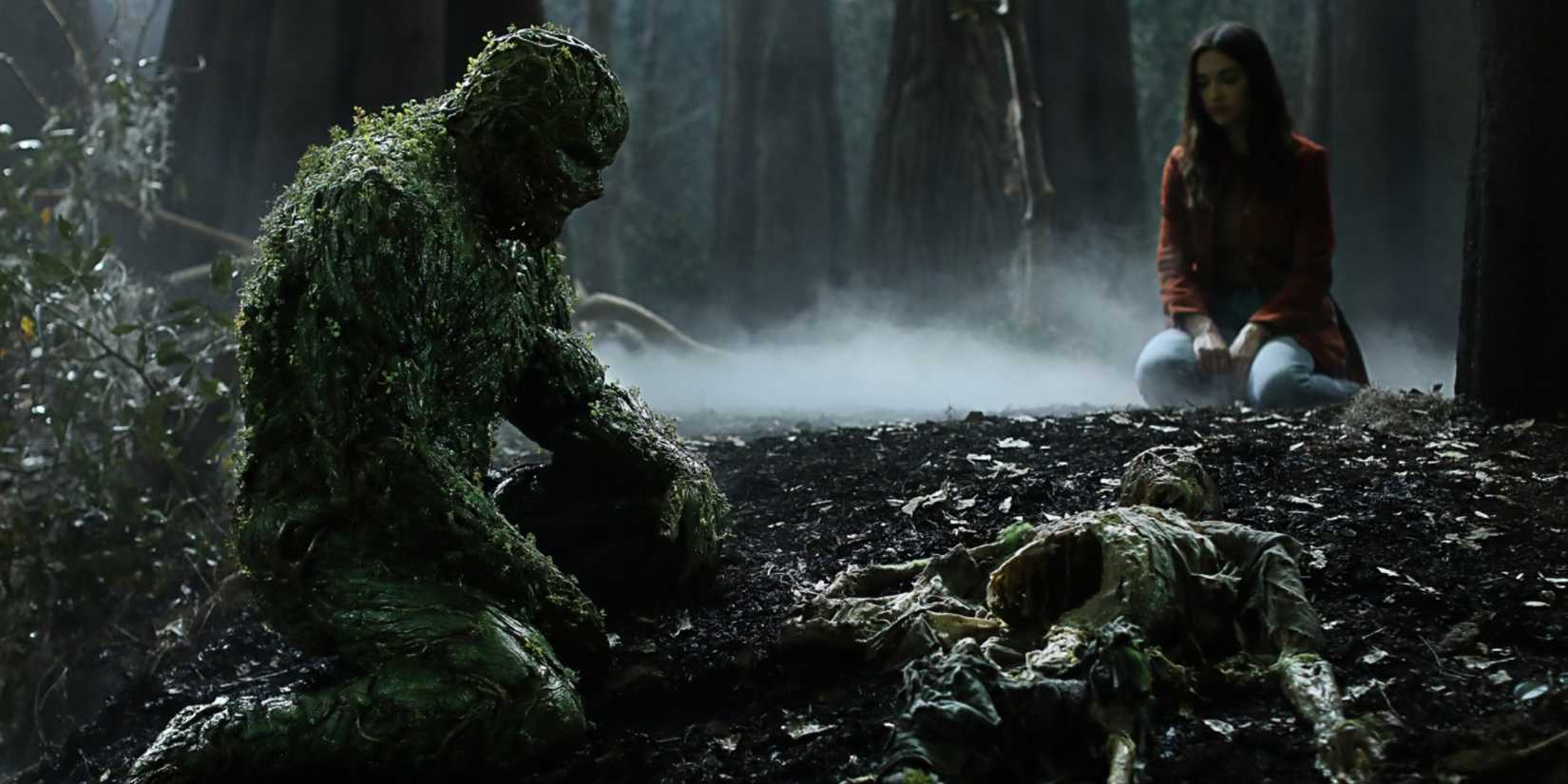 Swamp Thing and Abby Arcane kneel on the ground in the woods in Swamp Thing TV series.