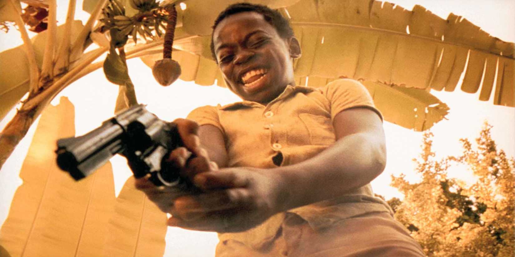 Lil Dice aiming a gun down in City of God