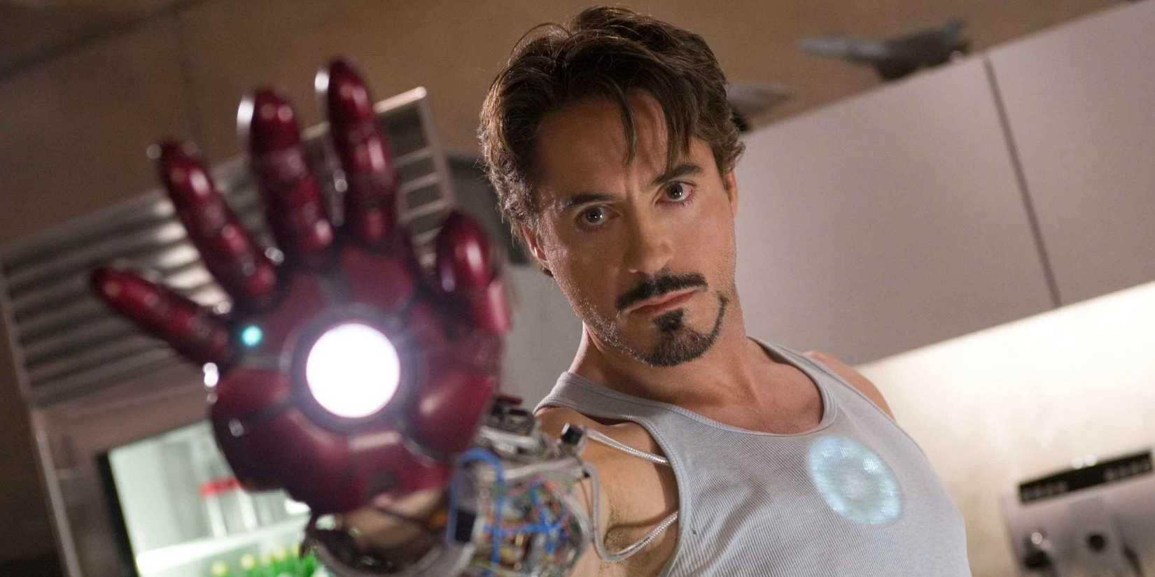 Robert Downey Jr as Tony Stark holding up robotic hand in Iron Man (2008)