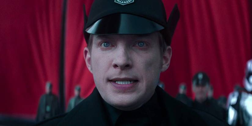 Domhnall Gleeson as General Hux looking ahead with officers behind him in The Force Awakens.
