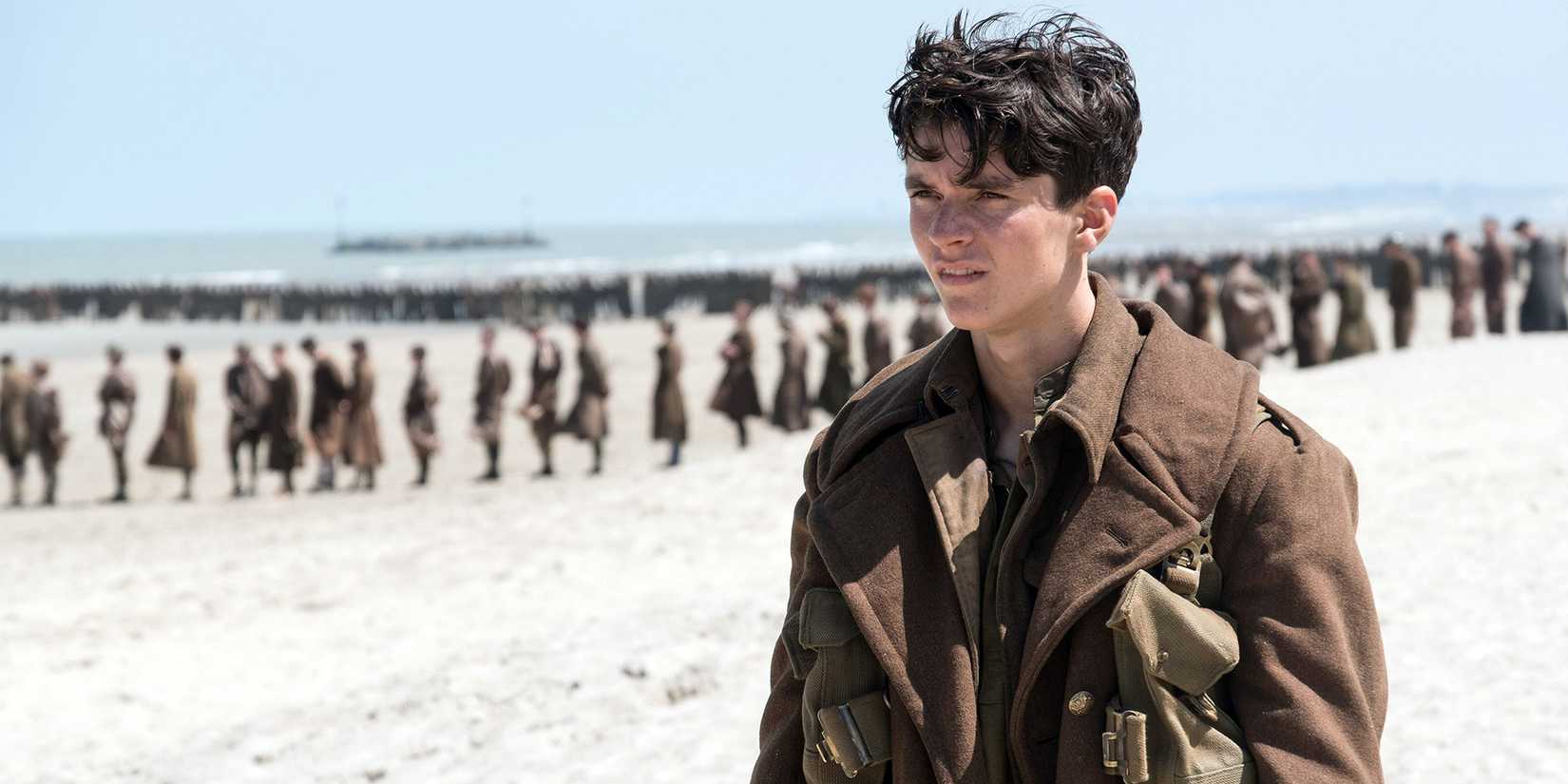 Fionn Whitehead as Tommy on the French beach with other British soldiers in 'Dunkirk'