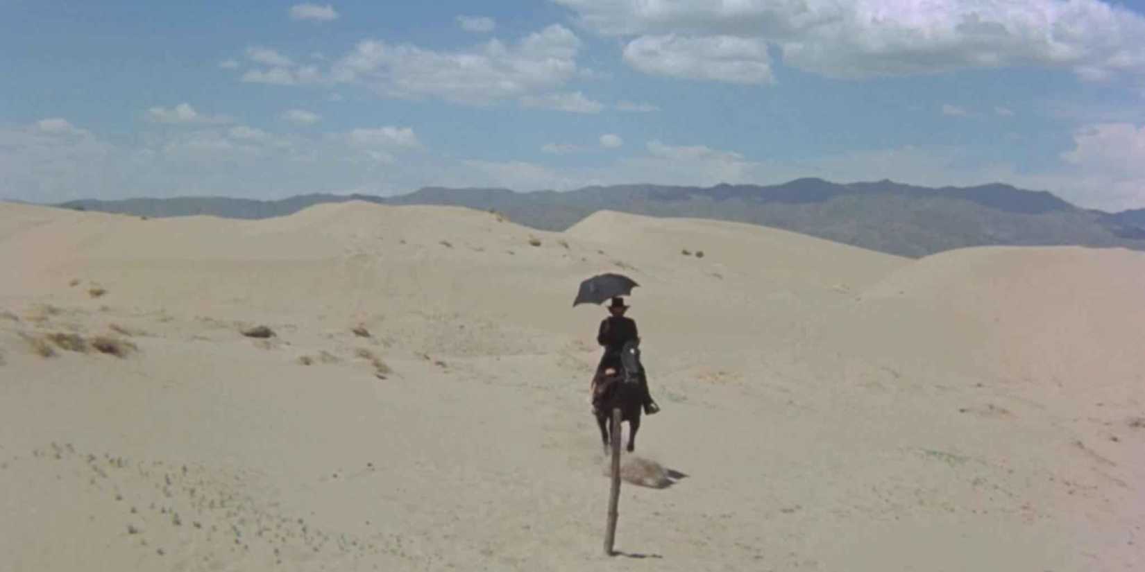 A man riding on horseback through the desert in El Topo (1970)