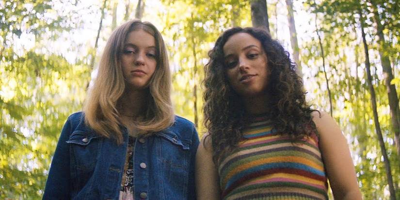 Sam and Deena on the woods looking down at something in Fear-Street-1994
