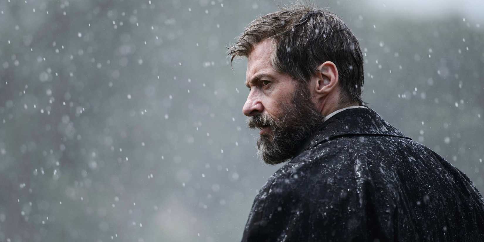 Aged superhero Logan aka The Wolverine stand in the rain in 'Logan'.