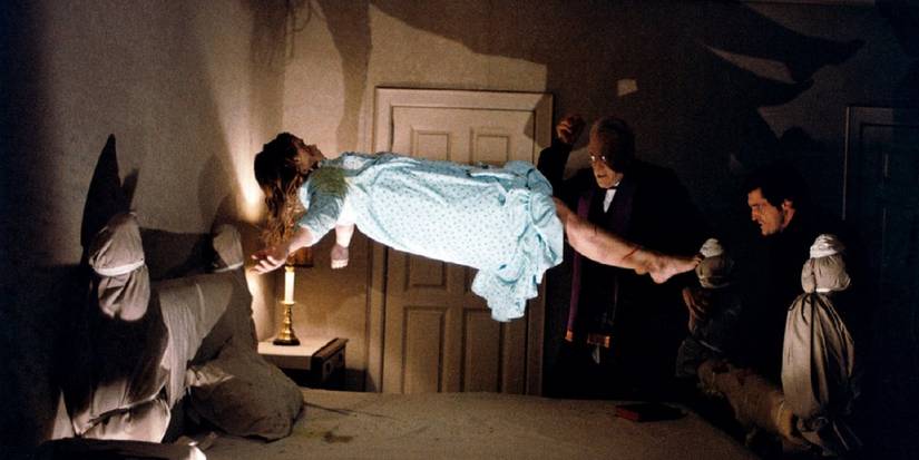 Linda Blair as Regan floating over her bed while two priests watch in The Exorcist