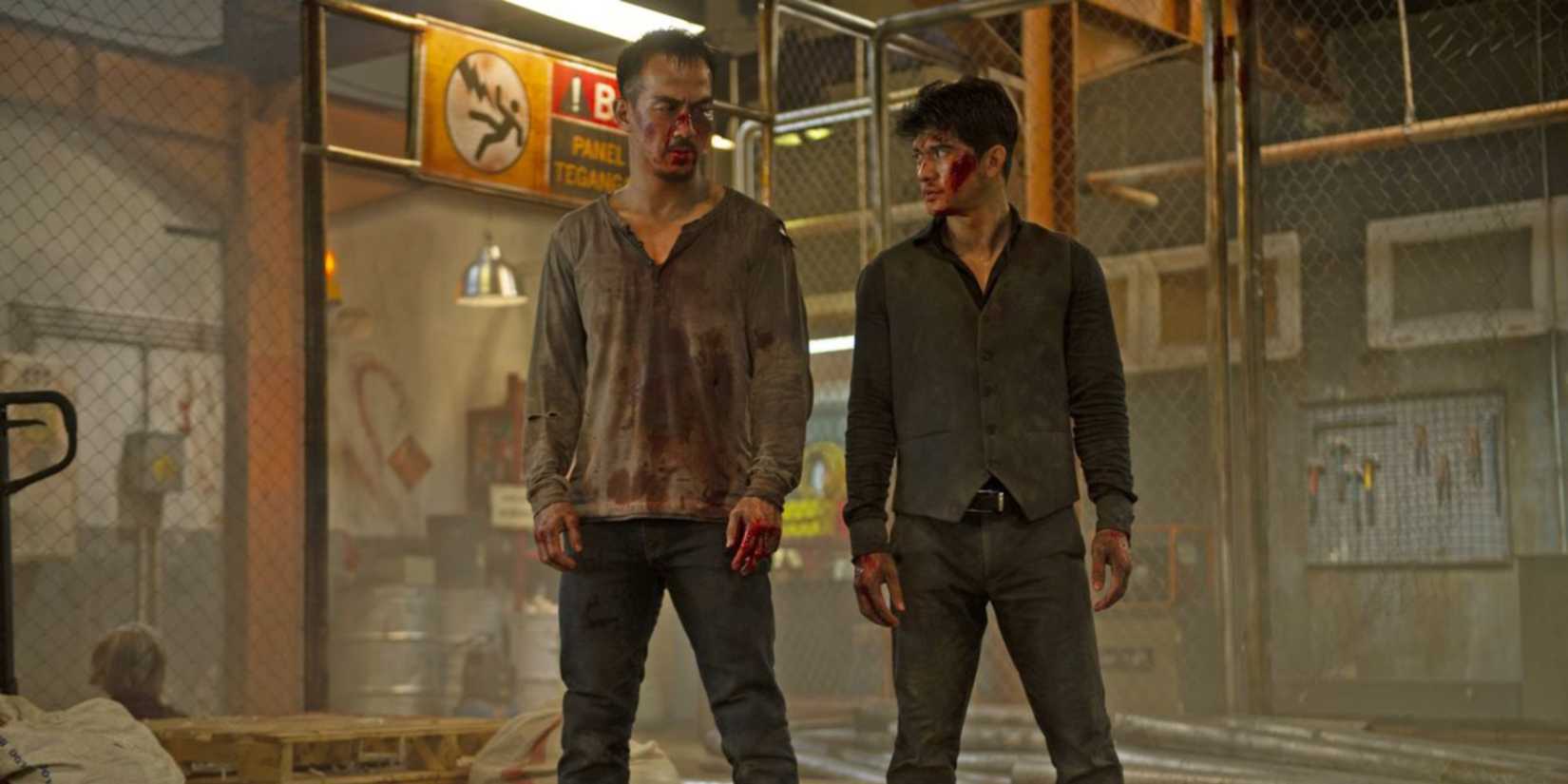 Joe Taslim and Iko Uwais look at each other as they stand bloodied after a brawl in The Night Comes for Us.