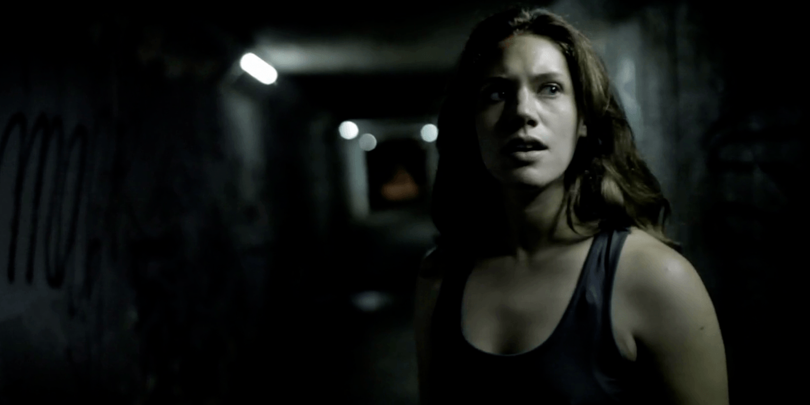 A woman looking confused in a dark room in Absentia