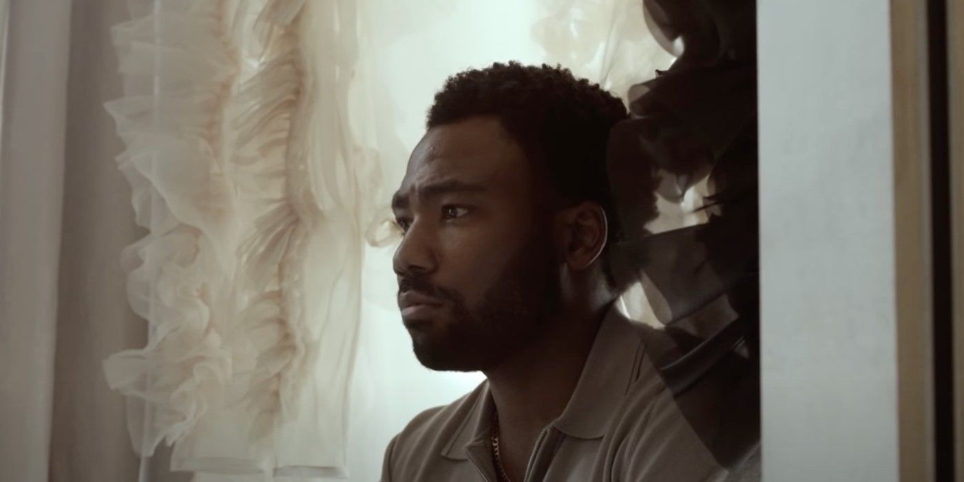 Donald Glover stares ahead beside lace curtains in Atlanta Season 3.