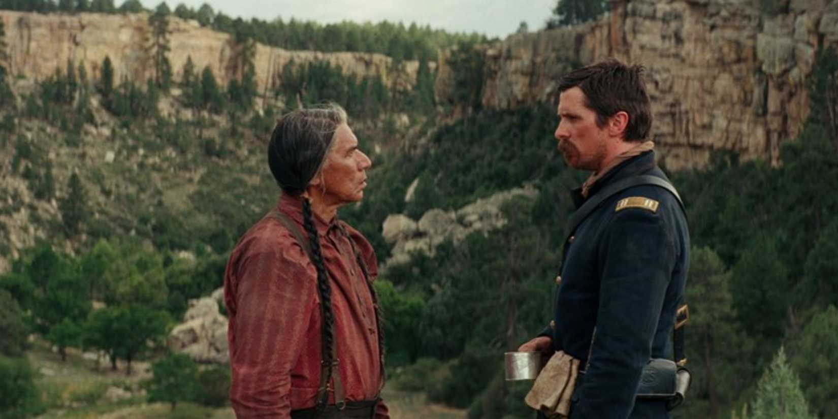 Wes Studi as Chief Yellow Hawk and Christian Bale as Captain Joseph Blocker in a conversation in Hostiles.