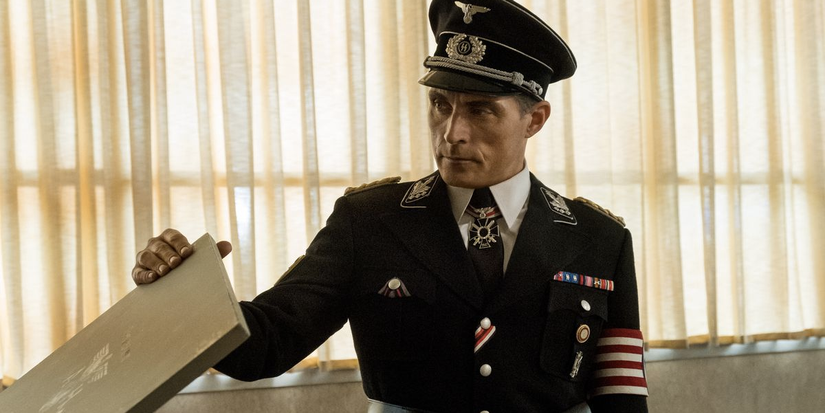 Rufus Sewell looks at a package in Man in High Castle