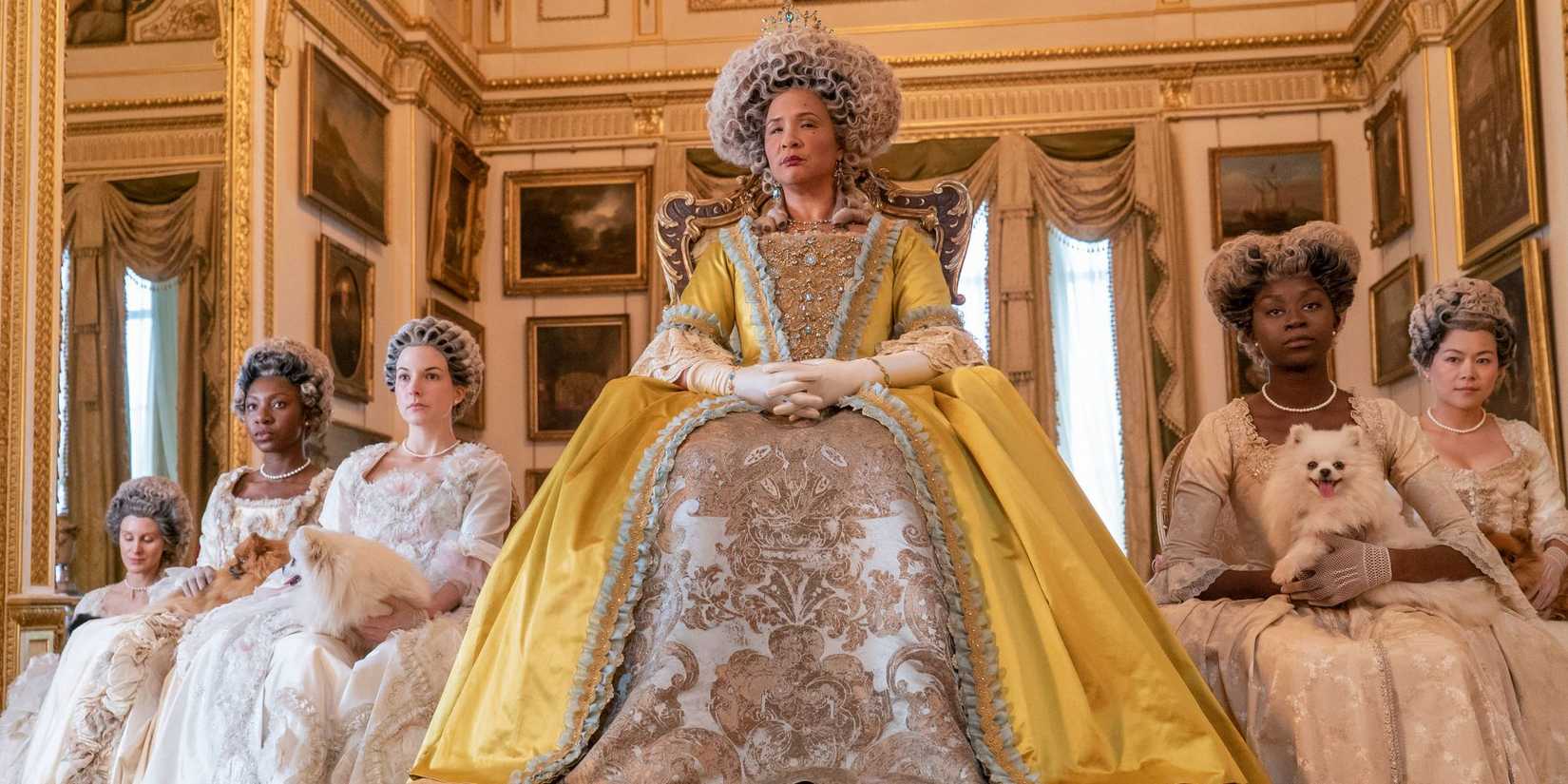Queen Charlotte, sitting on the throne next to her ladies in waiting in 'Bridgerton'