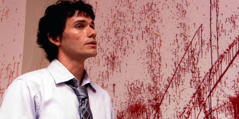 Brian Moser stands next to a blood splatter in Dexter.