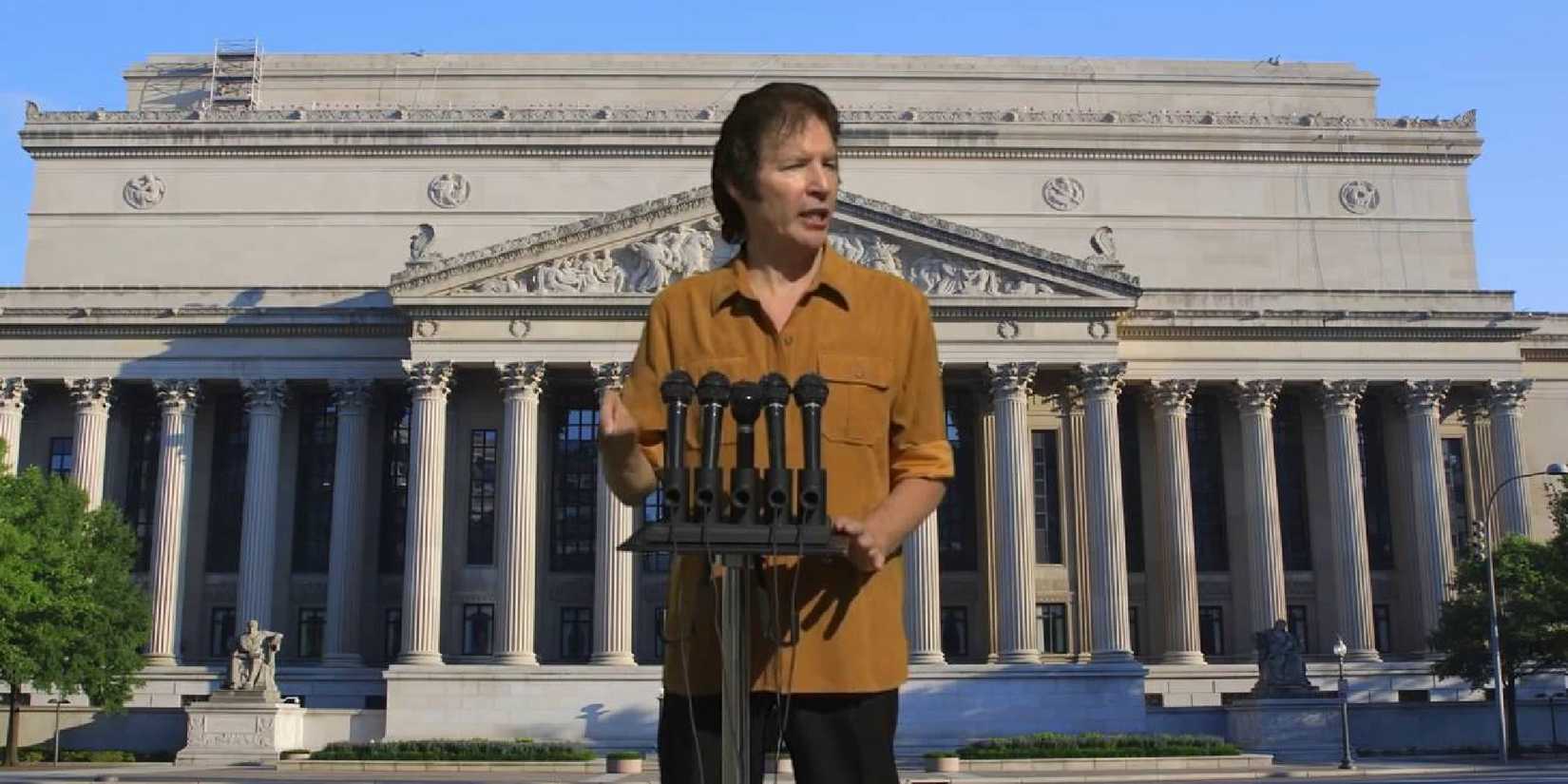 A man giving a conference with a building behind him in Fateful Findings